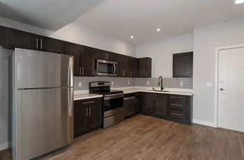 A kitchen with stainless steel appliances and dark wood cabinets
